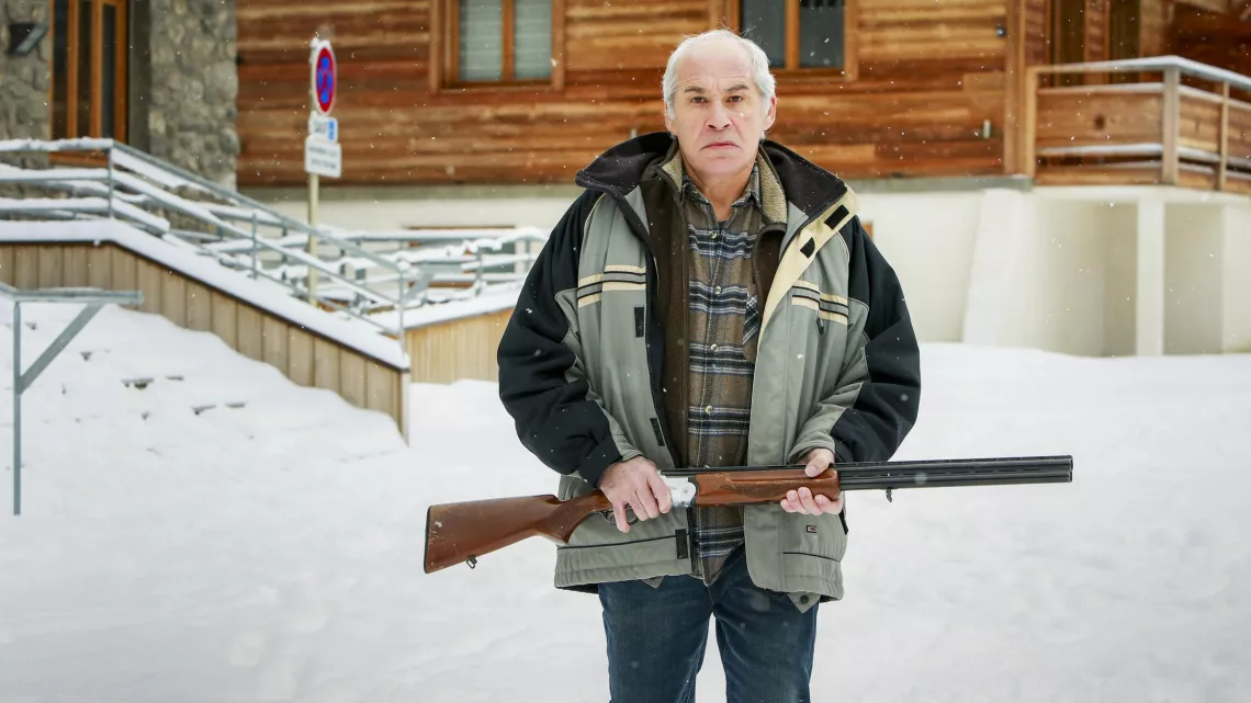 Jérôme Anger - Fabio dans les rues de Roches noires, tenant un fusil dans les mains