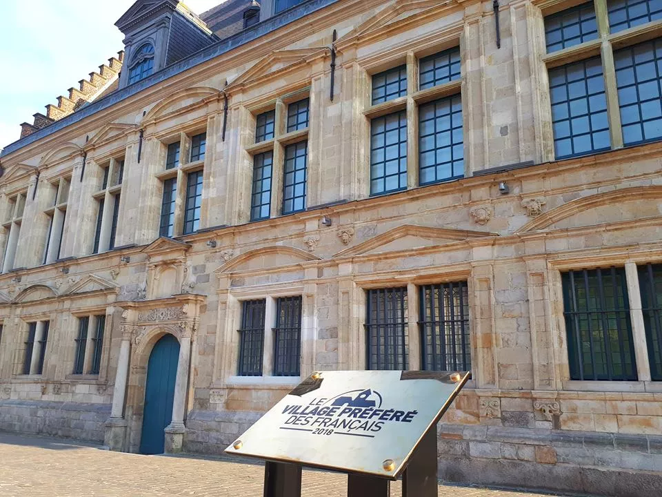 La plaque du Village préféré des Français 2018 La plaque "Le Village préféré des Français 2018" devant la façade d'un batiment à Cassel