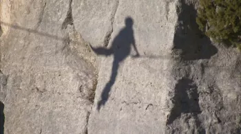 Ombre d'une silhouette assise sur un fil